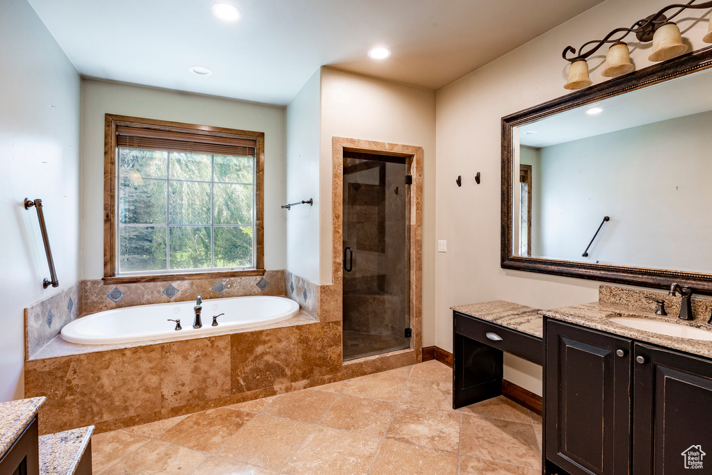 Bathroom featuring vanity, a bath, a stall shower, and recessed lighting