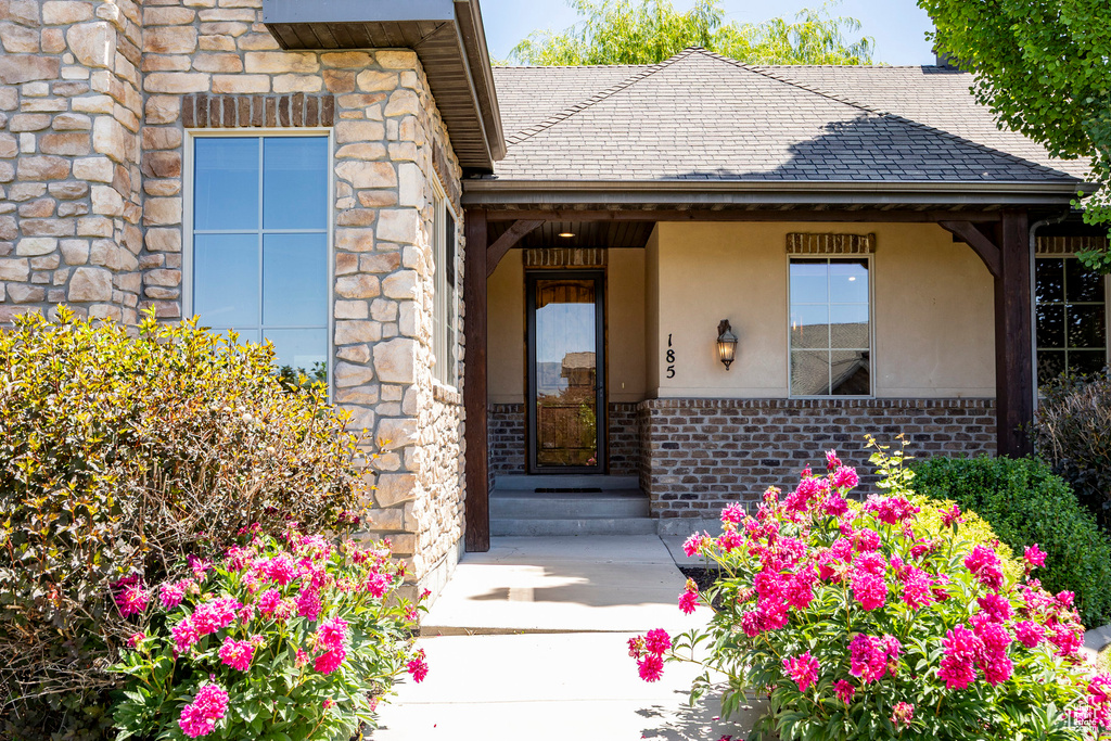 Entrance to property featuring stucco siding, stone siding, and brick siding