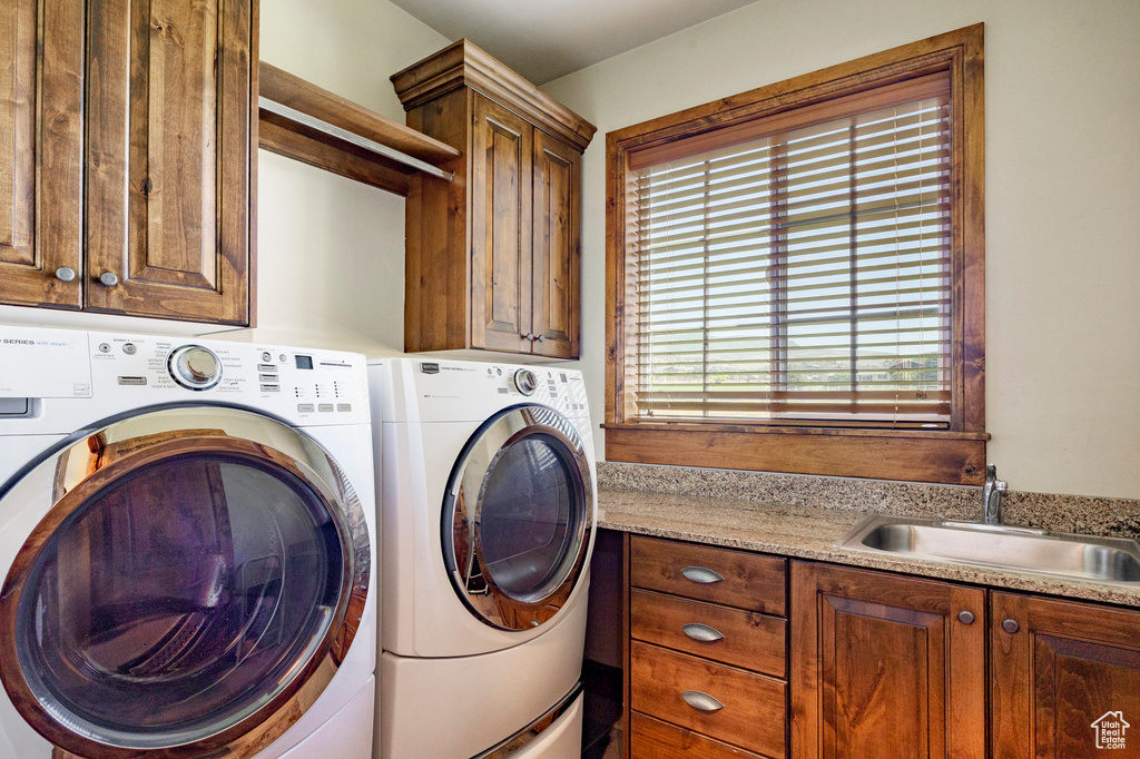 Washroom featuring cabinet space and washing machine and clothes dryer