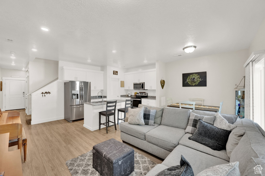 Living area featuring light wood-type flooring and recessed lighting