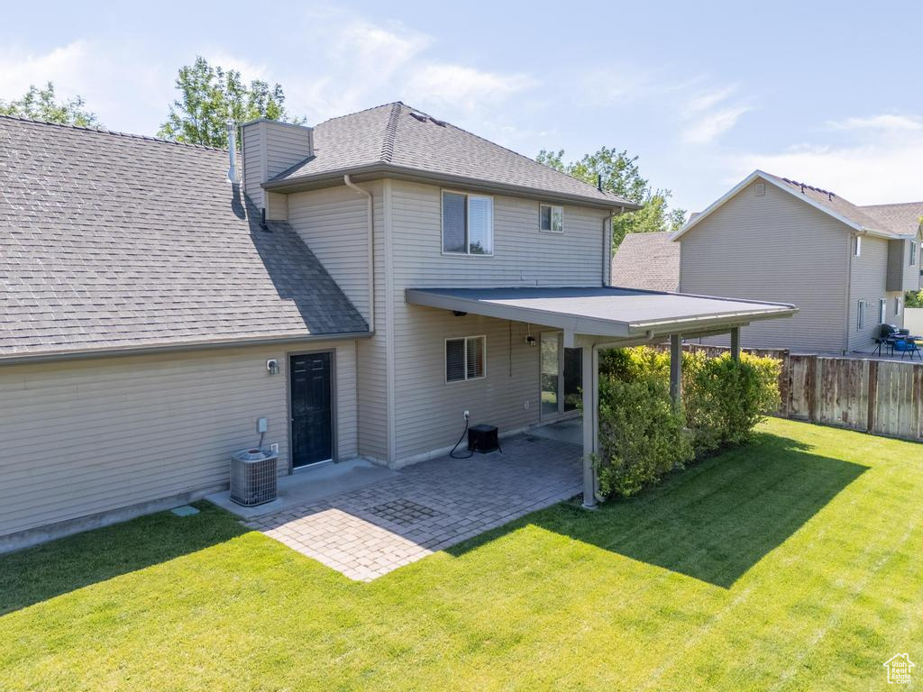 Back of house with roof with shingles, a patio, and a chimney