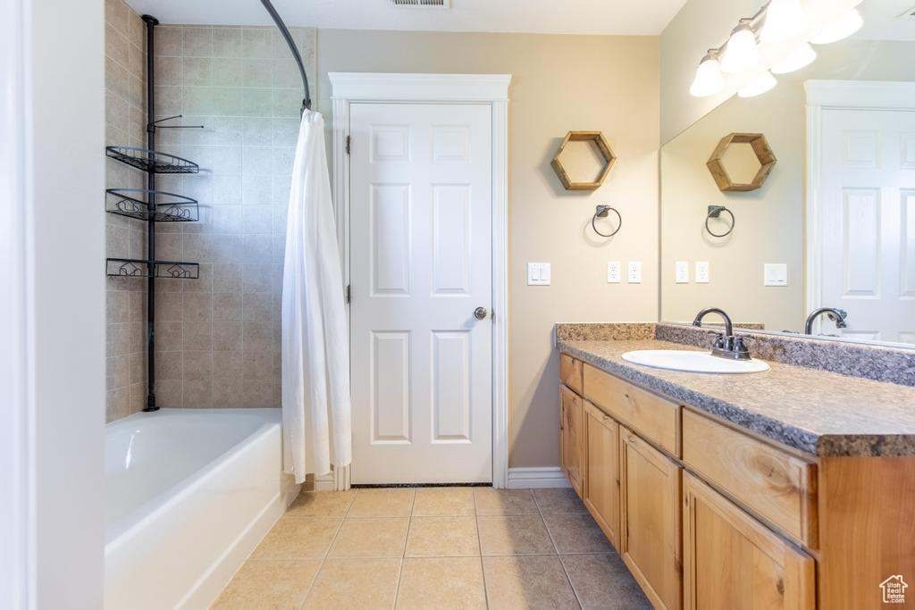 Full bathroom with tile patterned floors, vanity, and shower / tub combo