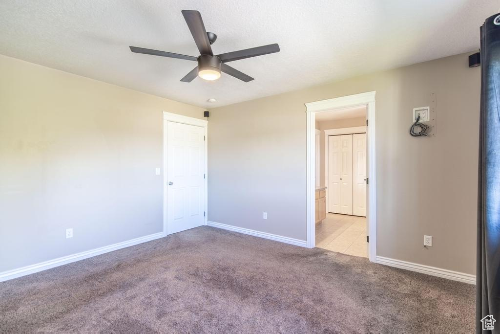 Unfurnished bedroom featuring carpet flooring and ceiling fan