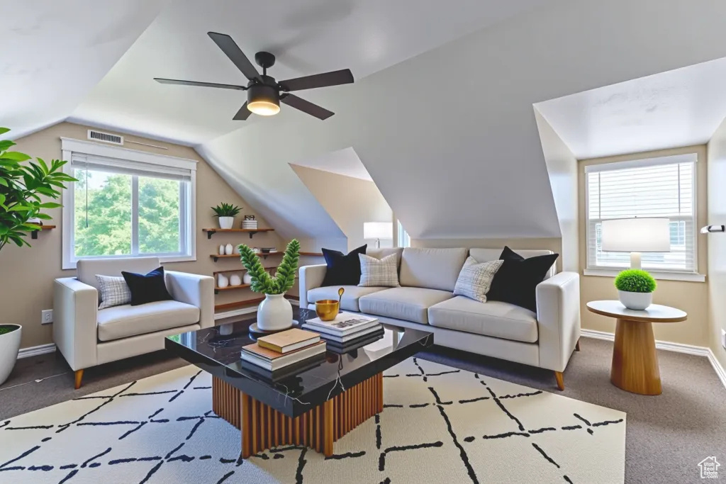 Carpeted living room with plenty of natural light, lofted ceiling, and a ceiling fan