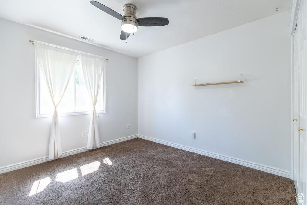 Spare room featuring carpet and a ceiling fan