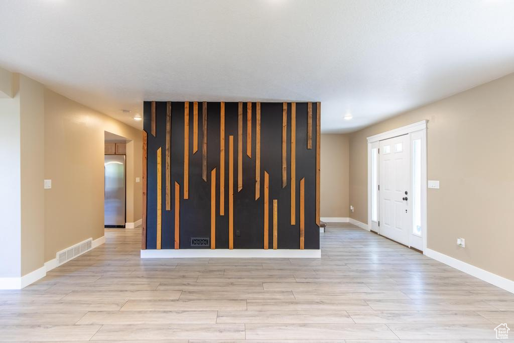 Spare room featuring light wood-style flooring and baseboards