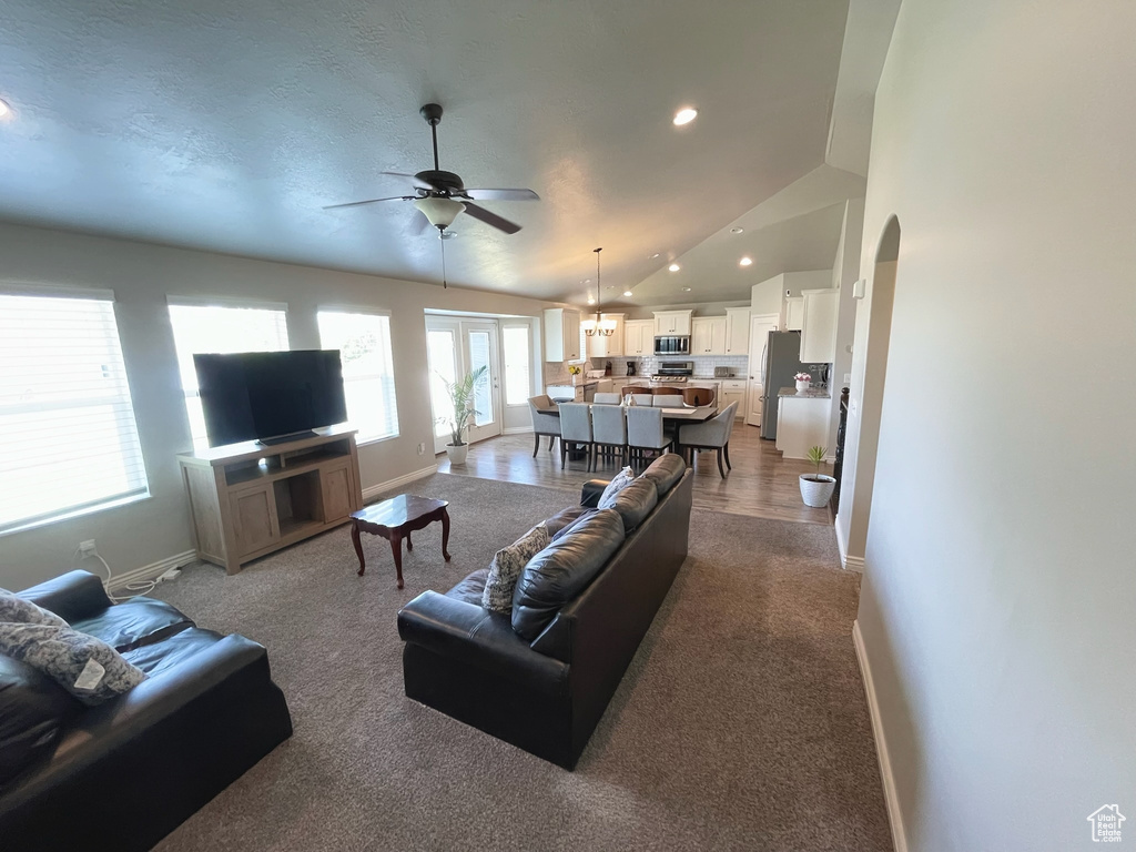 Living area featuring ceiling fan, arched walkways, carpet floors, recessed lighting, and vaulted ceiling