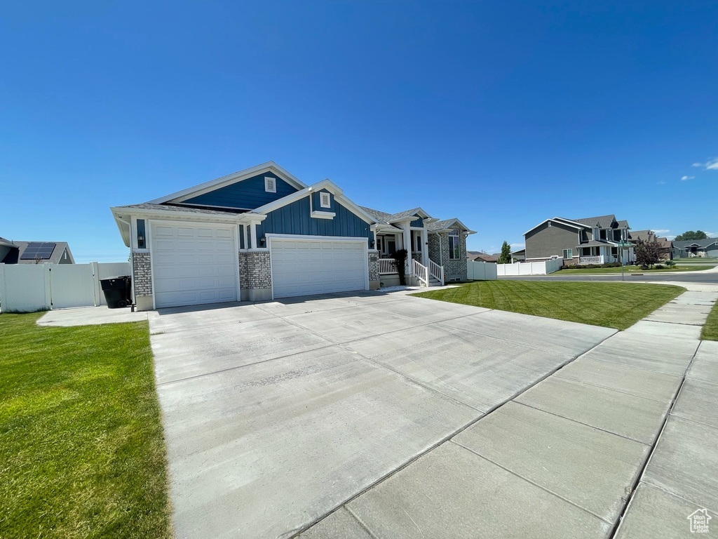 Single story home with a garage, concrete driveway, and board and batten siding