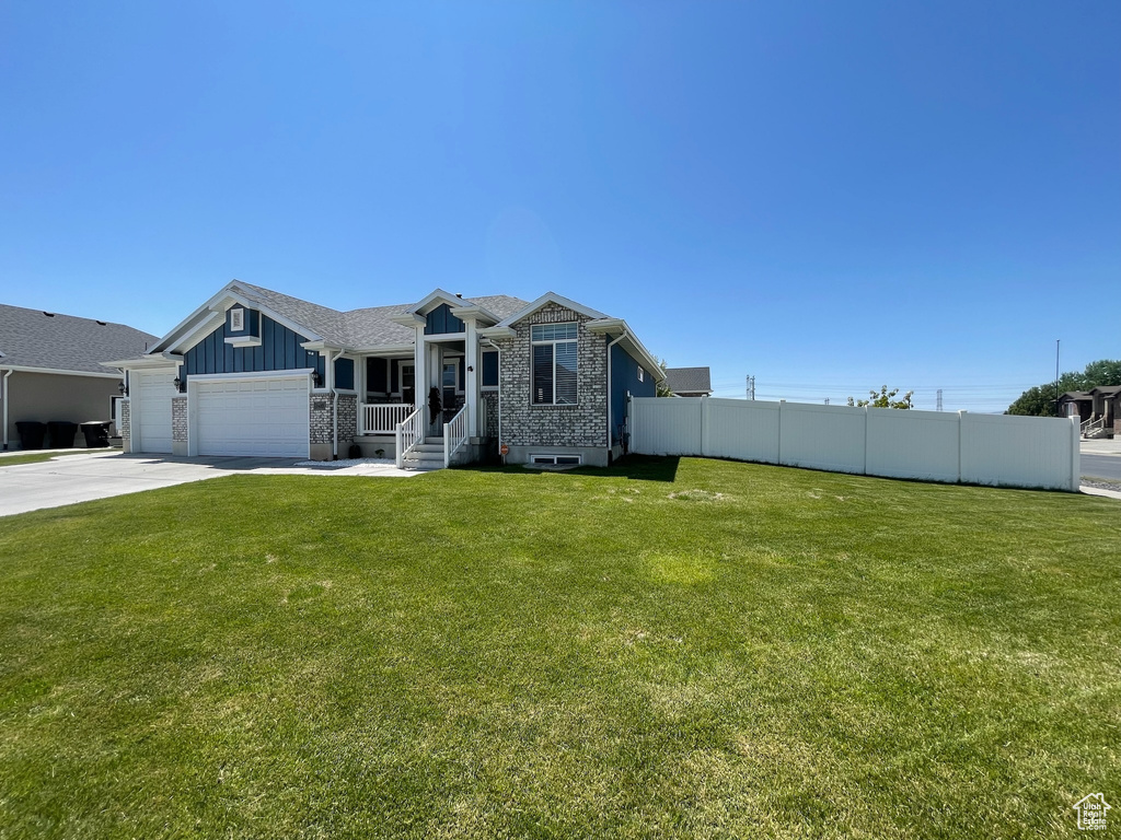 View of front of property featuring an attached garage, driveway, board and batten siding, and brick siding