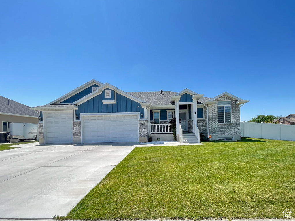 Ranch-style home featuring an attached garage, board and batten siding, driveway, and brick siding