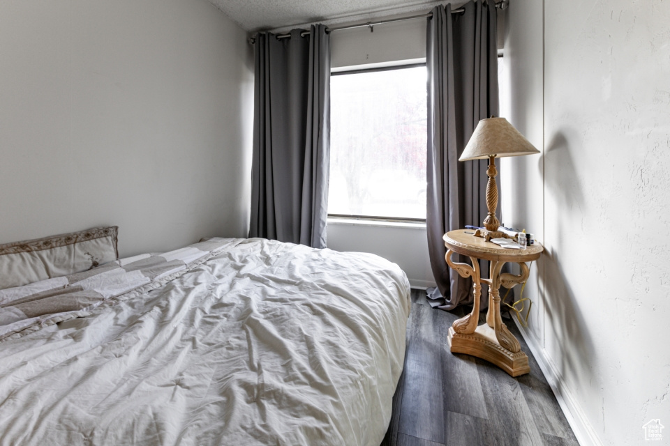 Bedroom with wood finished floors and a textured ceiling