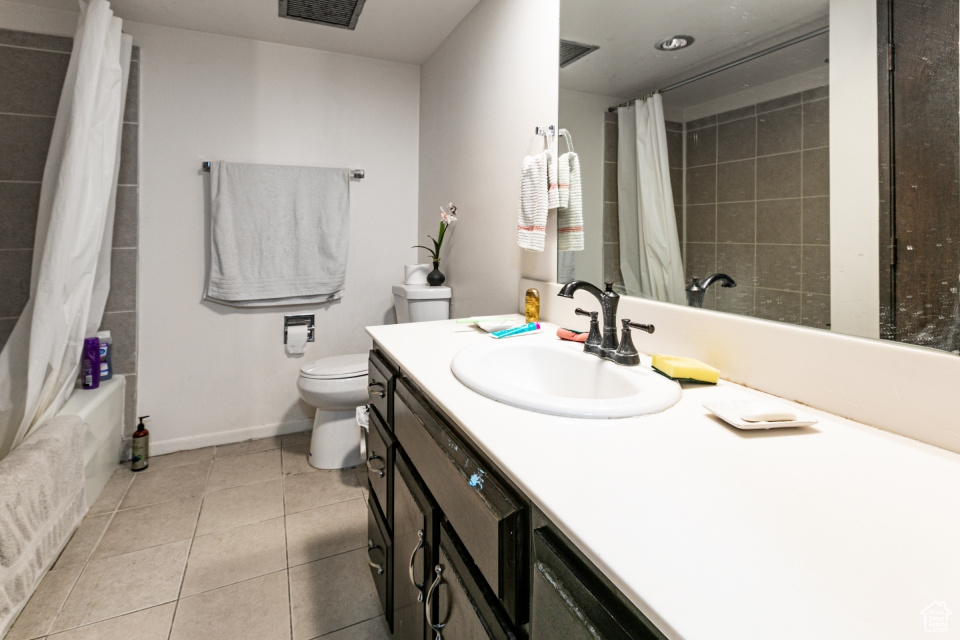 Full bathroom with vanity, tile patterned floors, and shower / bathtub combination with curtain