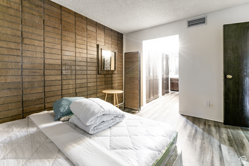Bedroom featuring wood finished floors and a textured ceiling
