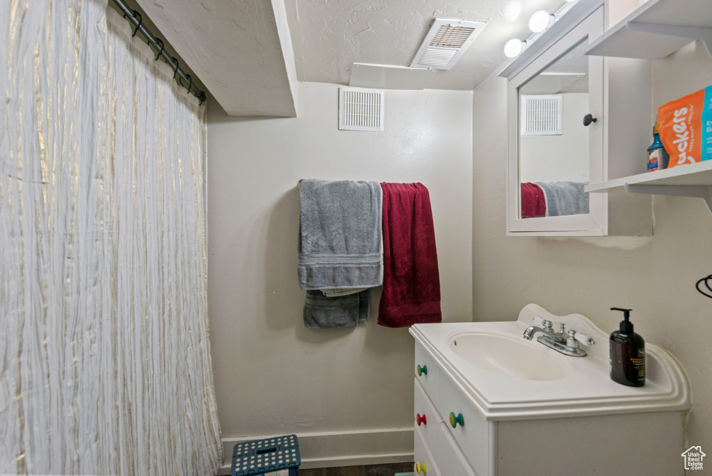 Full bath featuring vanity and baseboards