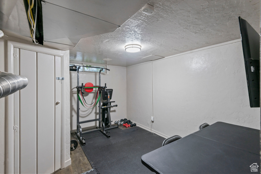 Workout room featuring a textured ceiling and baseboards