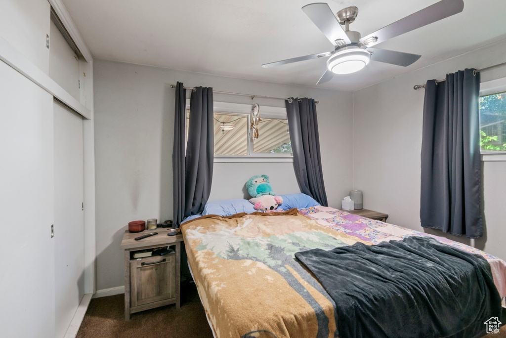 Bedroom featuring dark carpet, a closet, and ceiling fan
