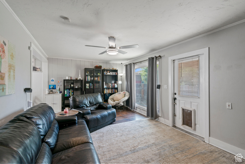Living area with a ceiling fan, crown molding, and wood finished floors