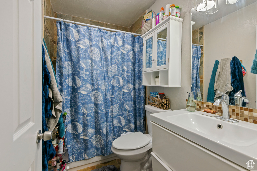 Full bath with vanity, tasteful backsplash, and curtained shower
