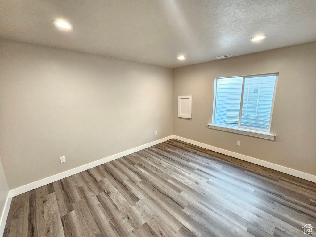 Spare room with recessed lighting, wood finished floors, and a textured ceiling