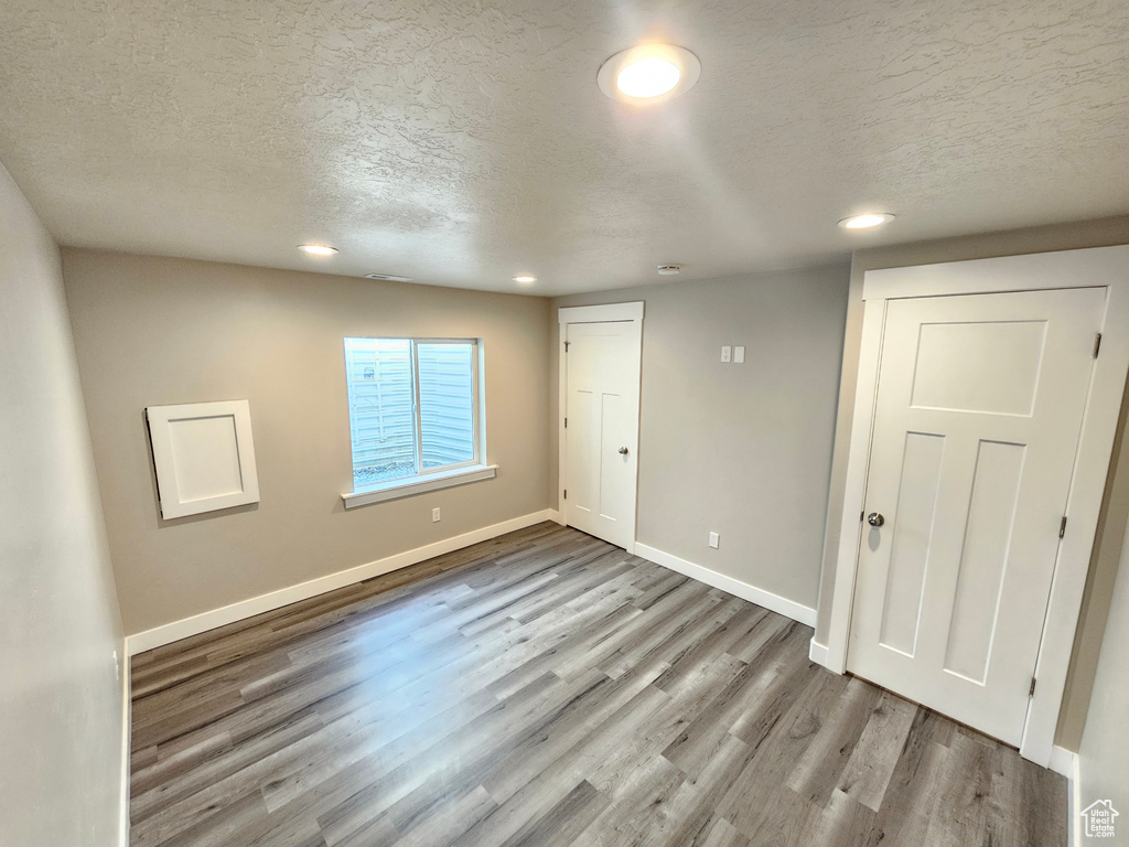 Unfurnished bedroom featuring wood finished floors, a textured ceiling, and recessed lighting