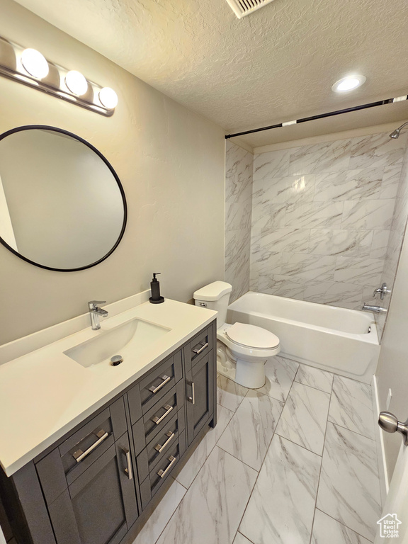 Full bathroom featuring vanity, marble look tiles, washtub / shower combination, a textured ceiling, and recessed lighting
