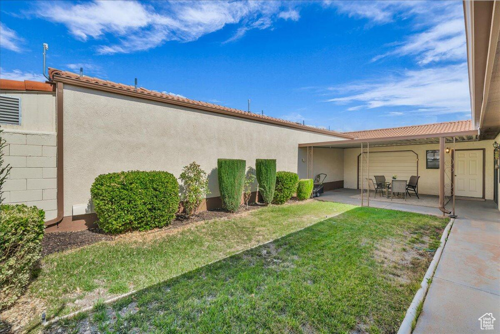 View of green lawn featuring a patio