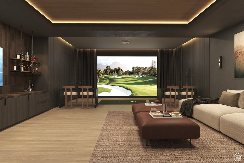 Cinema with a bar, a raised ceiling, and wood finished floors