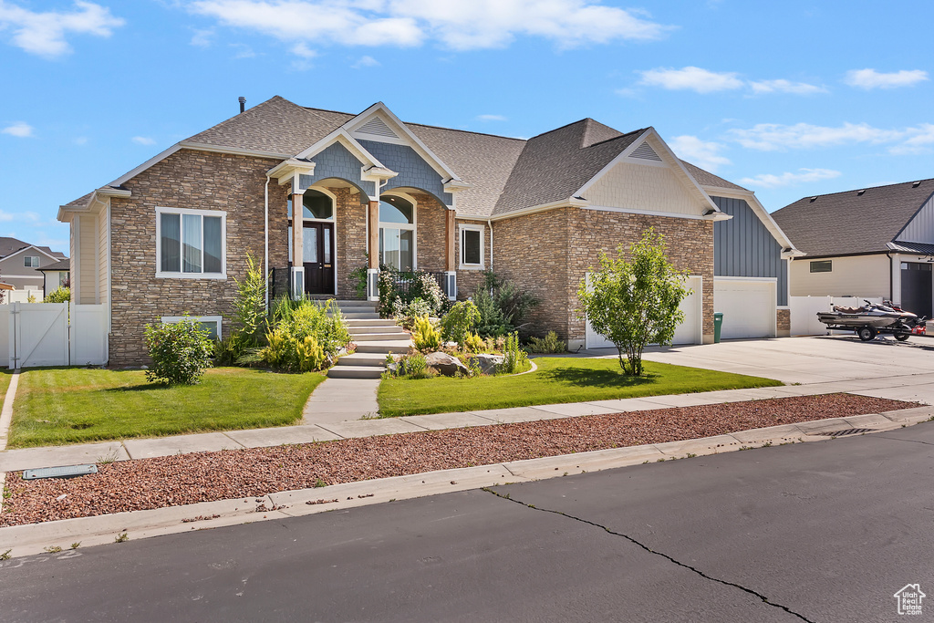 Craftsman-style house with concrete driveway, a gate, an attached garage, roof with shingles, and brick siding