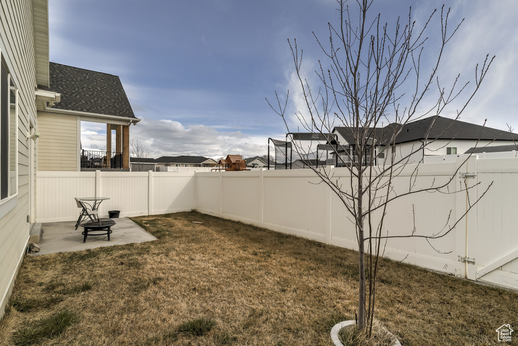 Fenced backyard featuring a patio and a residential view