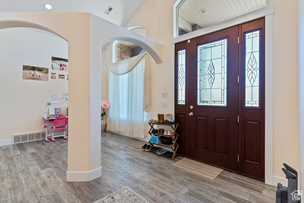 Entrance foyer featuring wood finished floors and a towering ceiling