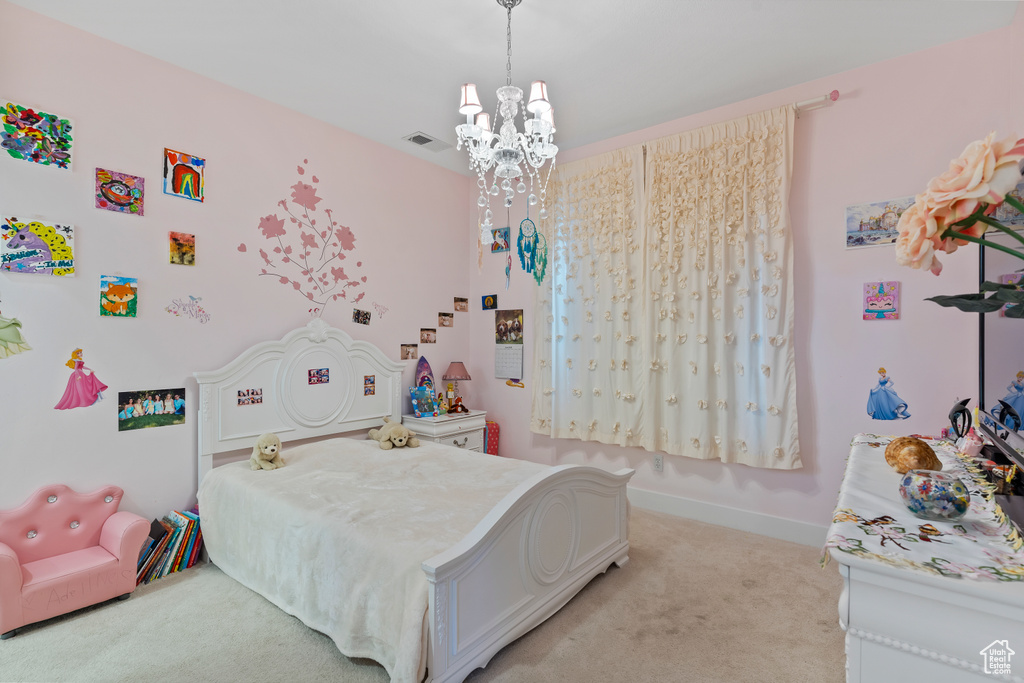 Bedroom featuring light colored carpet and a chandelier