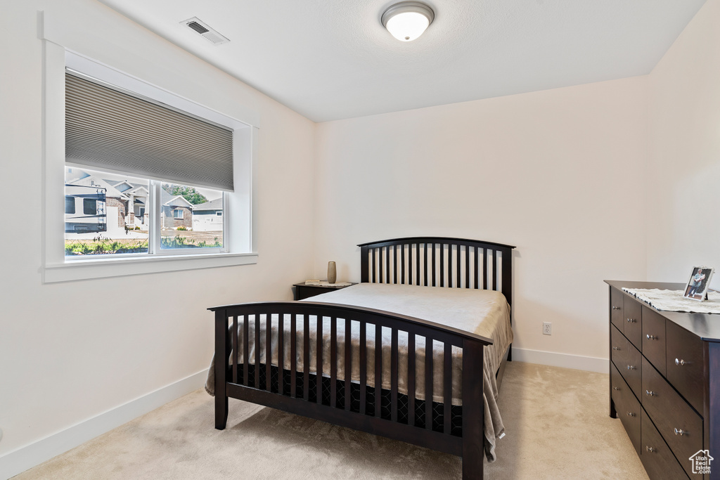 Bedroom featuring light colored carpet