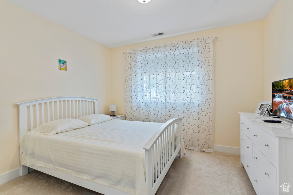 Bedroom with light carpet and baseboards