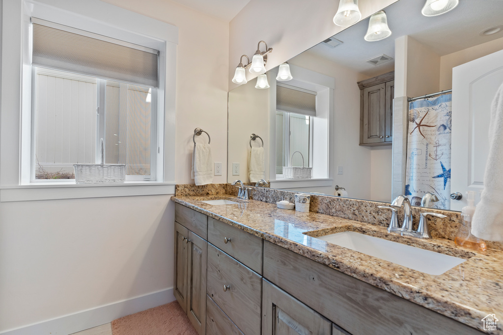 Bathroom featuring double vanity and baseboards