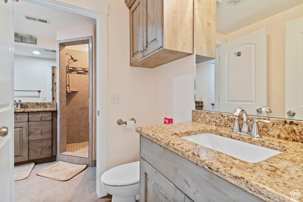 Bathroom with a shower stall, vanity, and tile patterned flooring