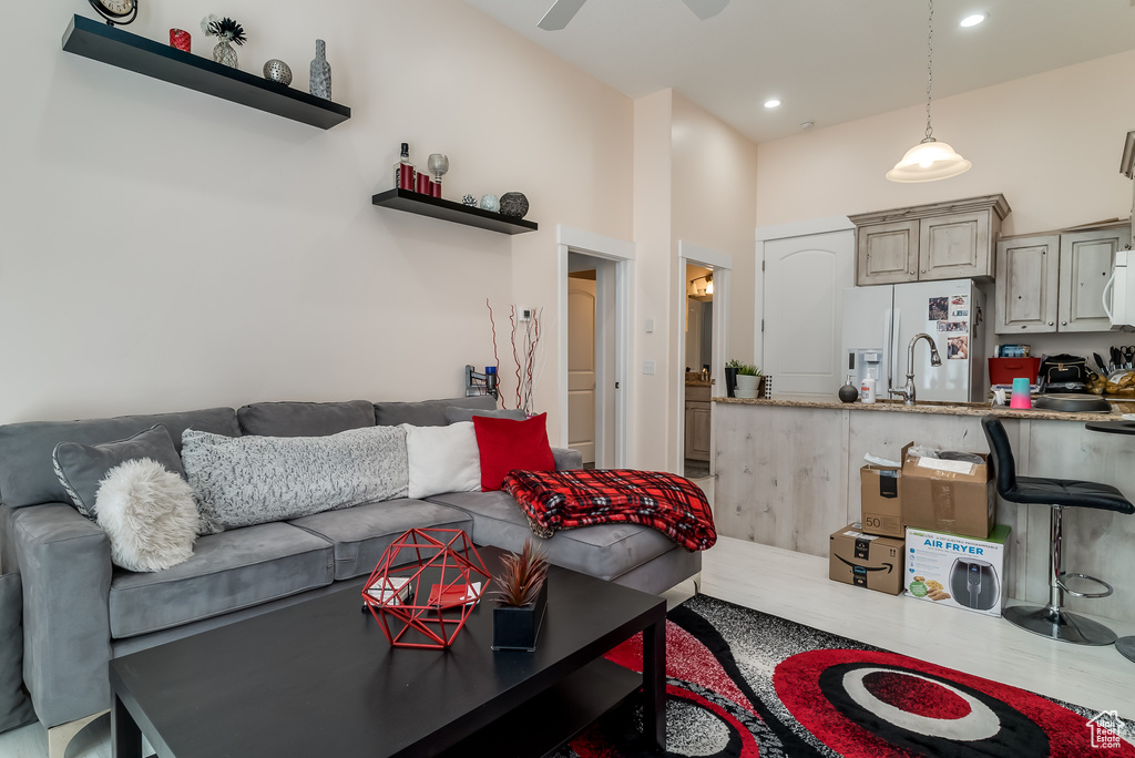 Living area with a towering ceiling, ceiling fan, and recessed lighting