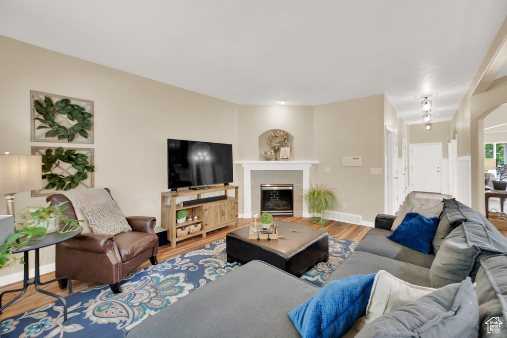 Living area with wood finished floors and a tiled fireplace