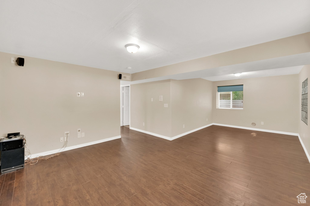 Empty room with baseboards and dark wood finished floors