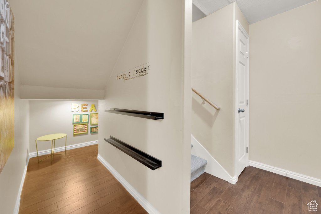Hallway featuring hardwood / wood-style floors and lofted ceiling