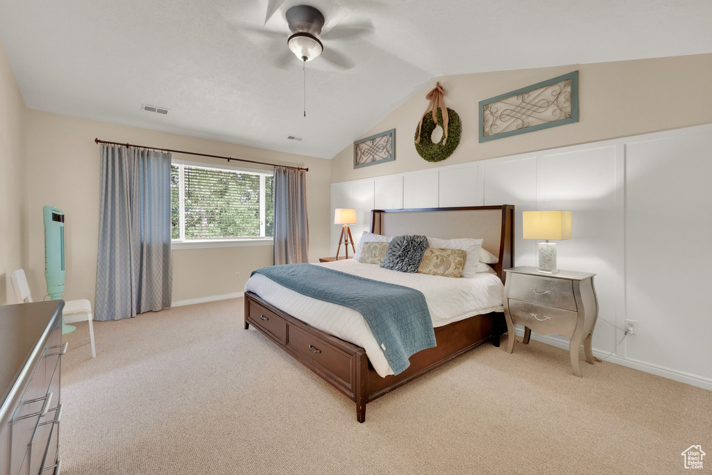 Bedroom with light colored carpet, lofted ceiling, and ceiling fan