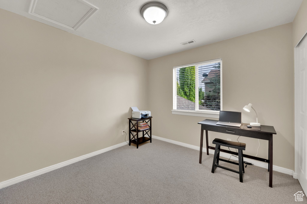 Carpeted home office featuring attic access and baseboards
