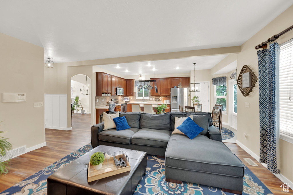 Living area featuring arched walkways, wood finished floors, and healthy amount of natural light