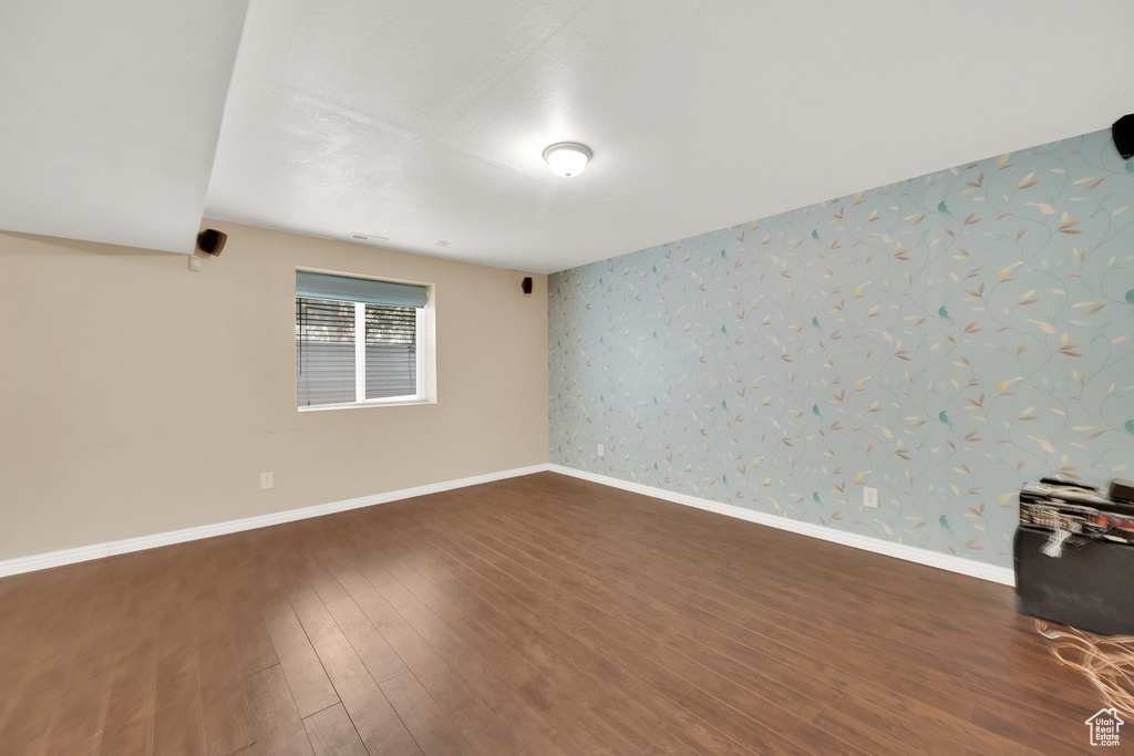 Unfurnished room with dark wood-style flooring