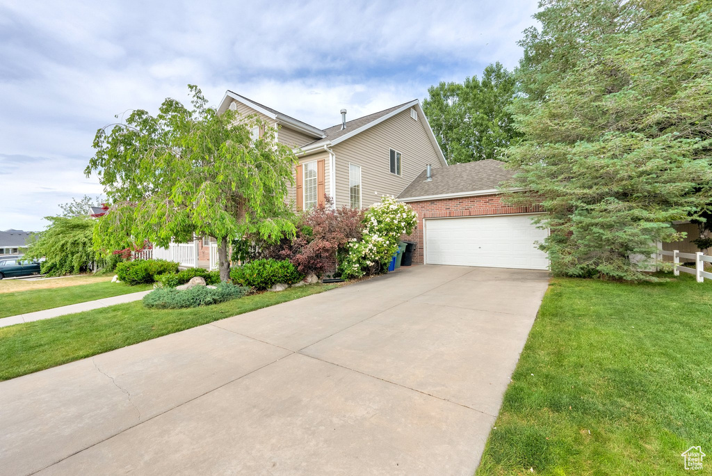 View of front of property with a garage, concrete driveway, brick siding, and a shingled roof