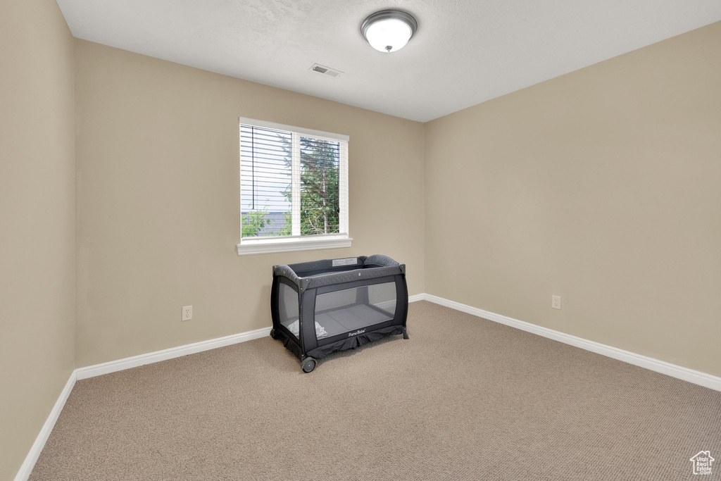 Empty room featuring carpet flooring and baseboards