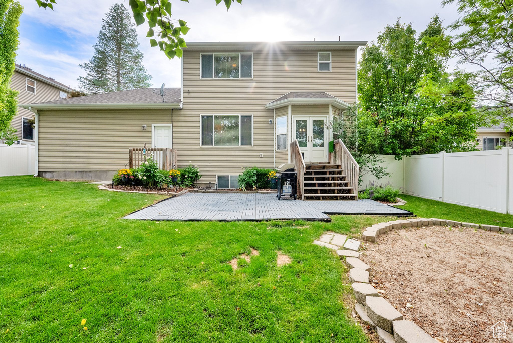 Rear view of house with french doors, a deck, and a fenced backyard