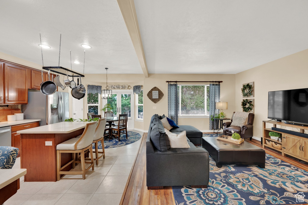 Living area featuring a chandelier, beam ceiling, and light tile patterned floors