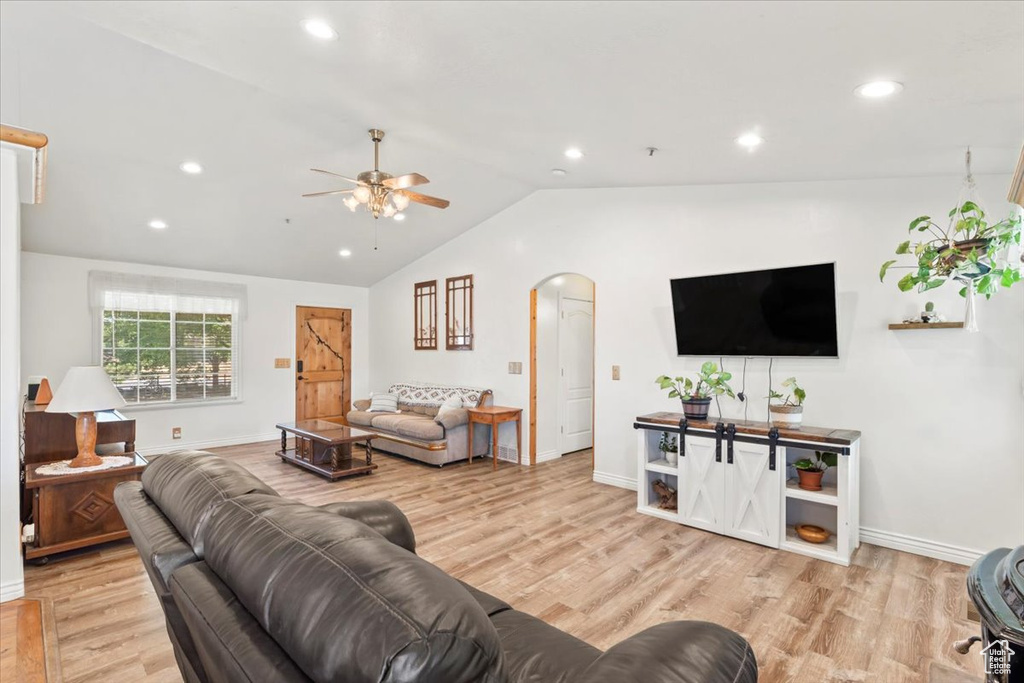 Living room featuring arched walkways, ceiling fan, wood finished floors, lofted ceiling, and recessed lighting