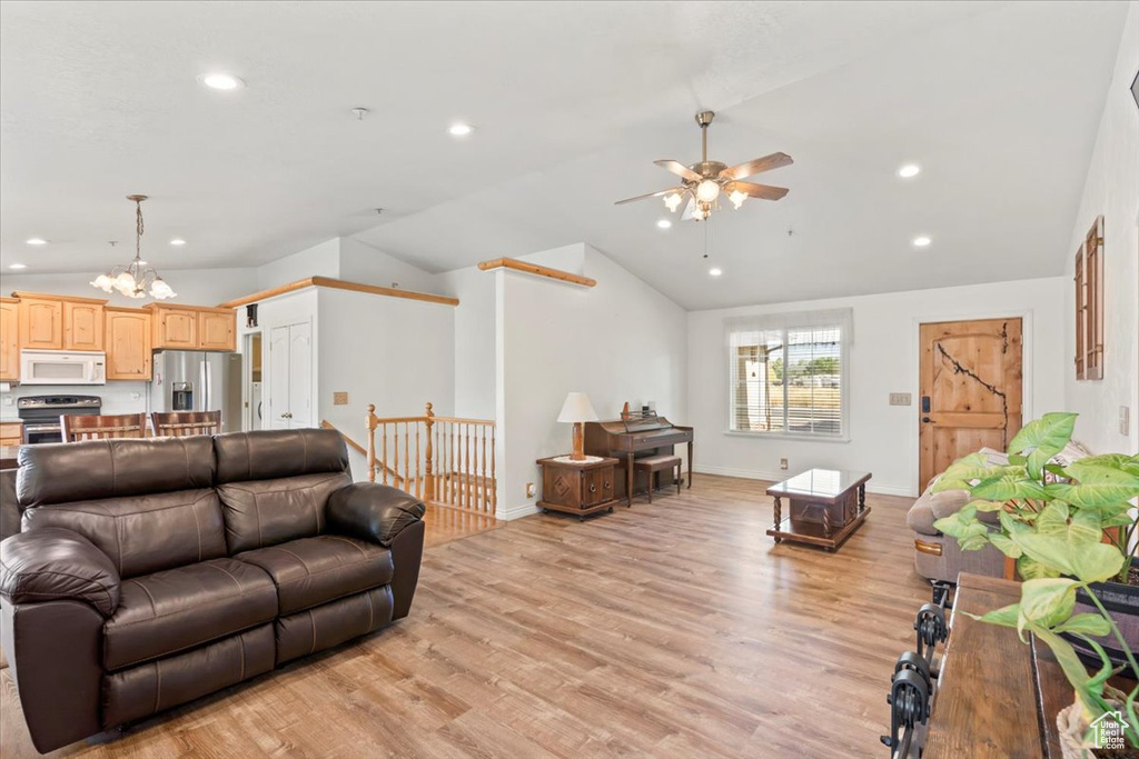 Living area with lofted ceiling, a ceiling fan, a chandelier, light wood-style floors, and recessed lighting