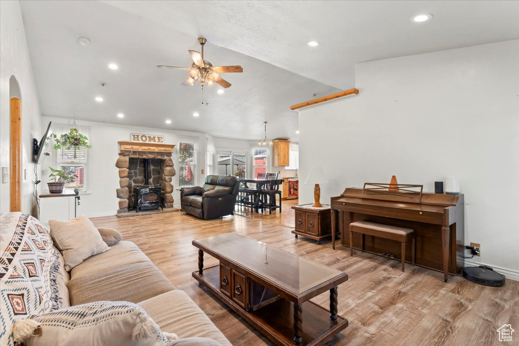 Living room featuring ceiling fan, arched walkways, recessed lighting, vaulted ceiling, and light wood-type flooring